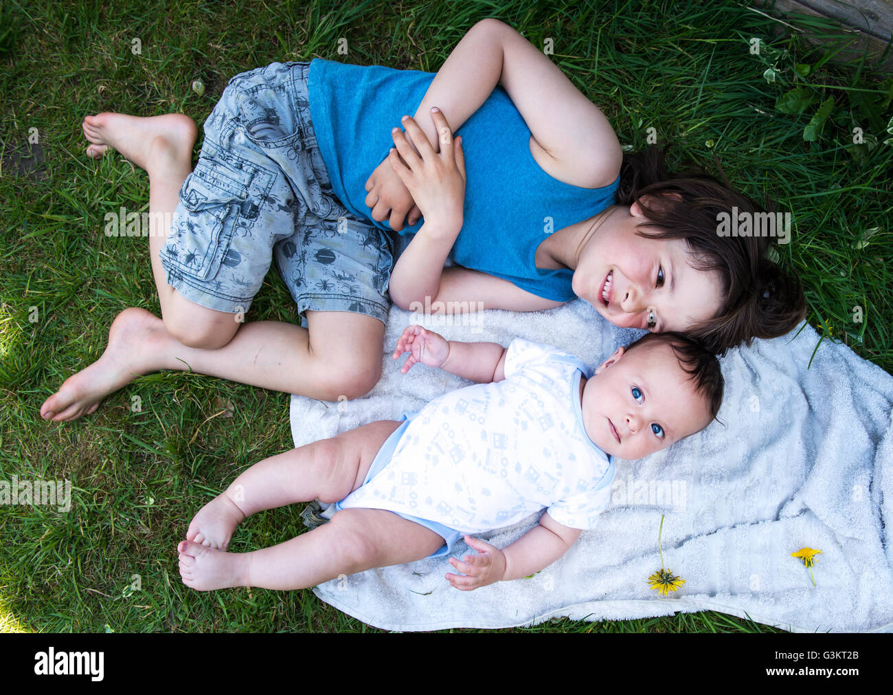 Vista aerea del ragazzo e baby fratello giacente in giardino Foto Stock