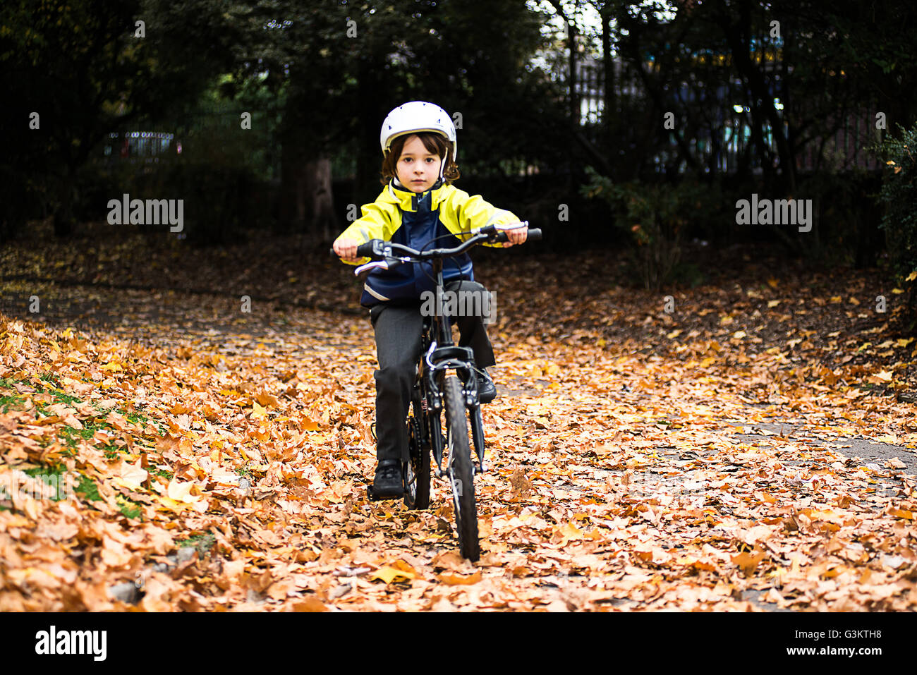 Ragazzo in park indossando il casco IN BICICLETTA Bicicletta Equitazione Foto Stock