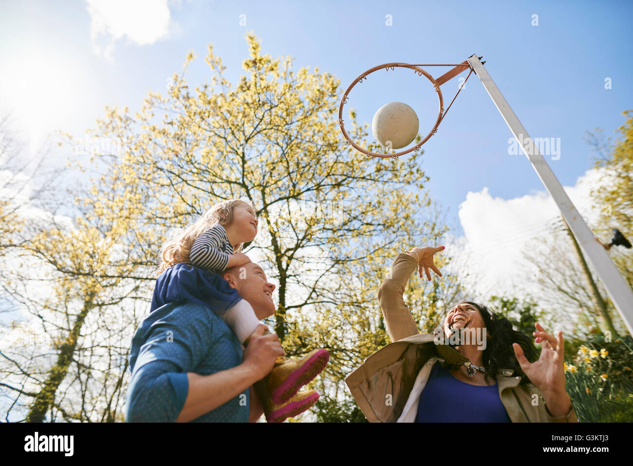 Famiglia di gettare la pallacanestro attraverso Basketball hoop Foto Stock