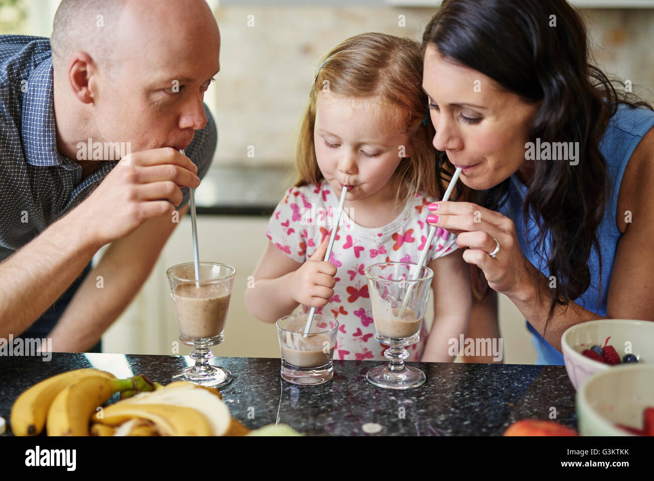 Famiglia frullato da bere con cannucce Foto Stock