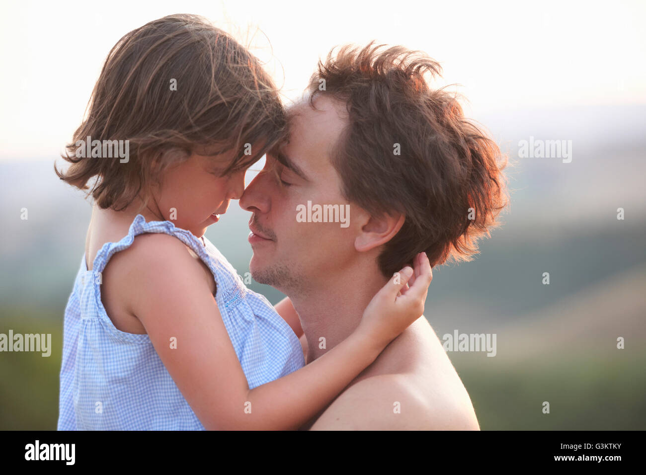Ritratto di un uomo e di una figlia faccia a faccia con gli occhi chiusi, Buonconvento, Toscana, Italia Foto Stock