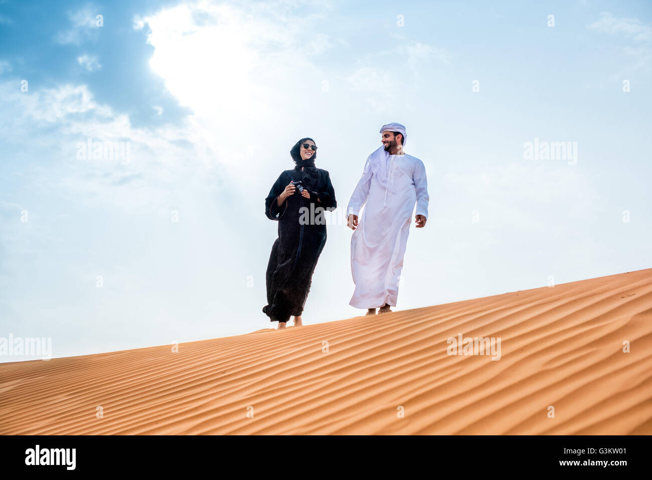 Giovane indossando il tradizionale del medio oriente a piedi vestiti sulle  dune del deserto, Dubai, Emirati Arabi Uniti Foto stock - Alamy
