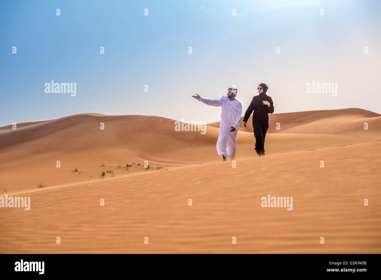 Giovane indossando il tradizionale medio orientale di puntamento vestiti dalle dune del deserto, Dubai, Emirati Arabi Uniti Foto Stock