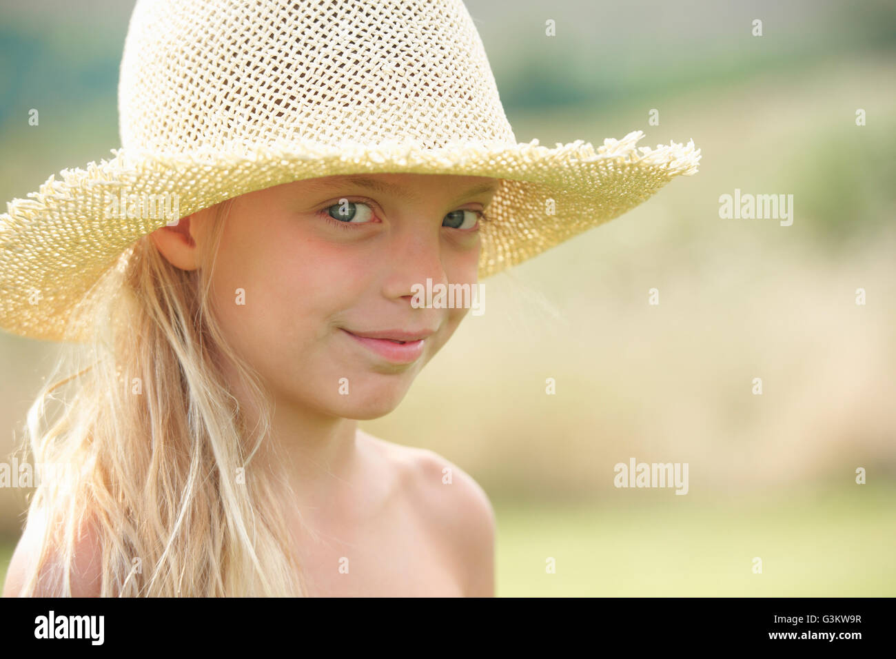 Ritratto di giovane ragazza all'aperto, indossare un cappello di paglia Foto Stock