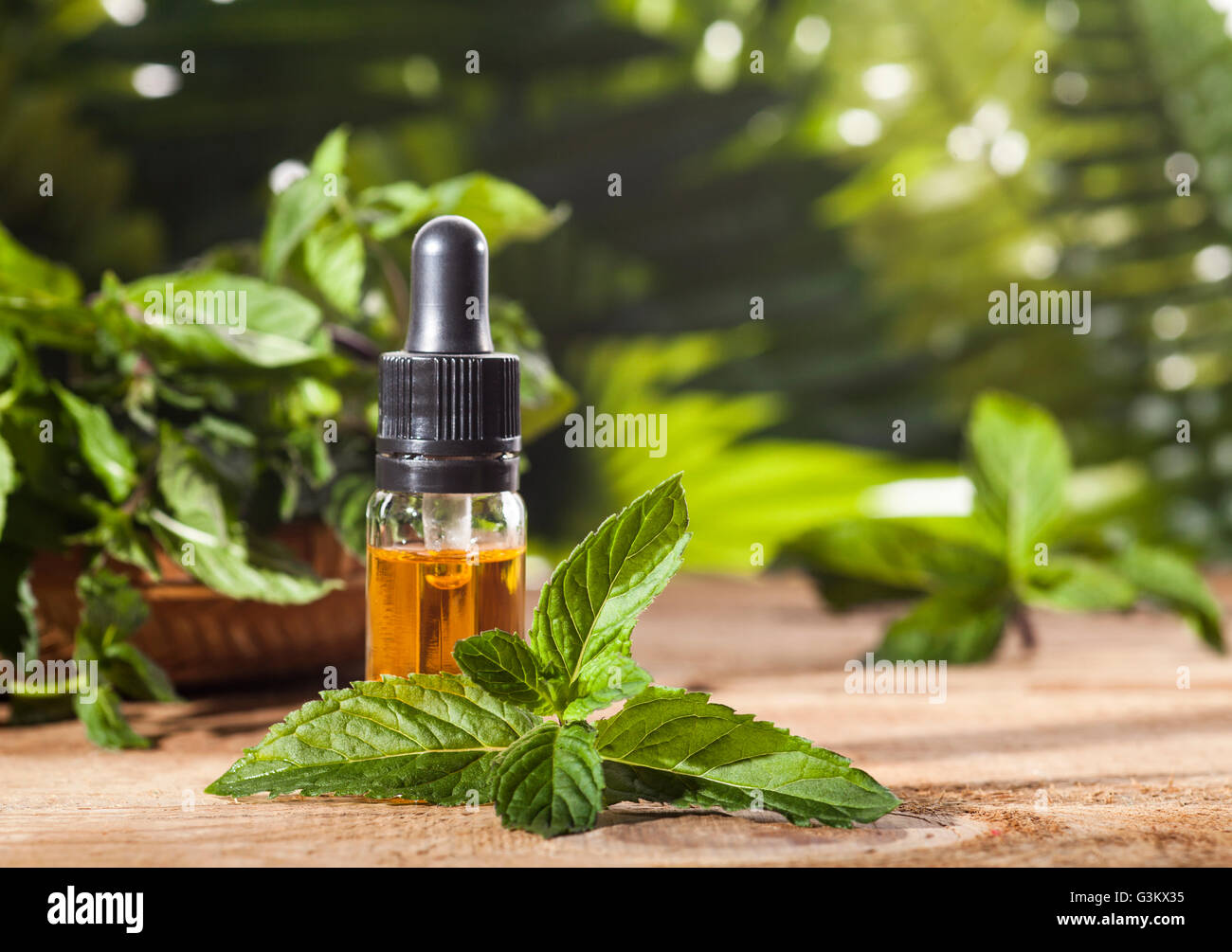 Aroma essenziale con olio di menta piperita su sfondo di legno. Messa a fuoco selettiva, orizzontale. Foto Stock
