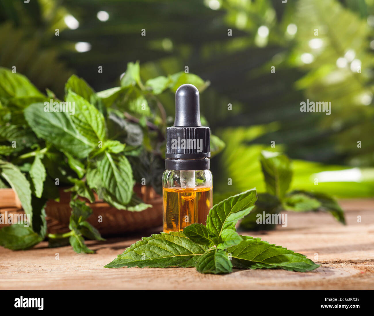 Aroma essenziale con olio di menta piperita su sfondo di legno. Messa a fuoco selettiva, orizzontale. Foto Stock