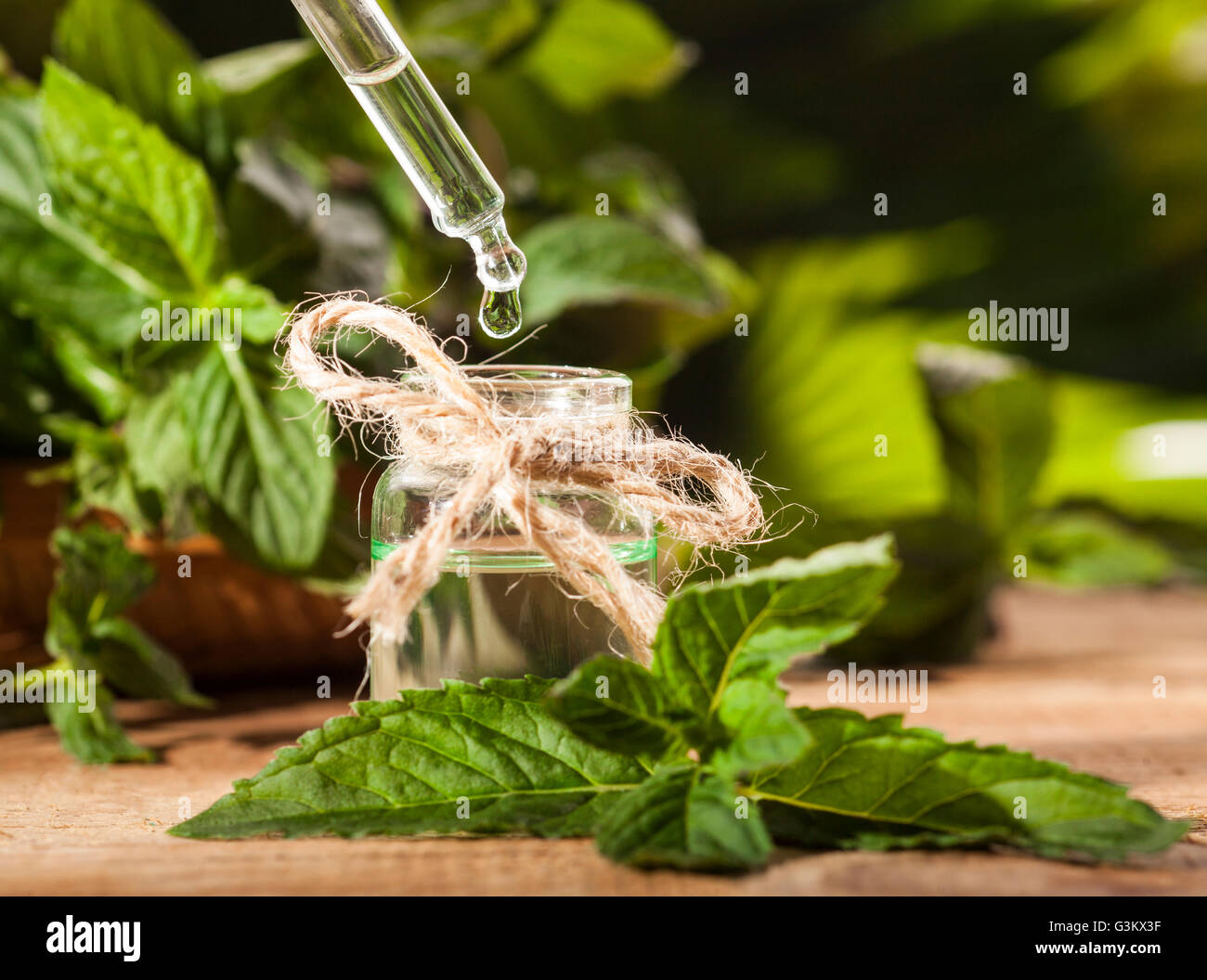 Aroma essenziale con olio di menta piperita su sfondo di legno. Messa a fuoco selettiva, orizzontale. Foto Stock