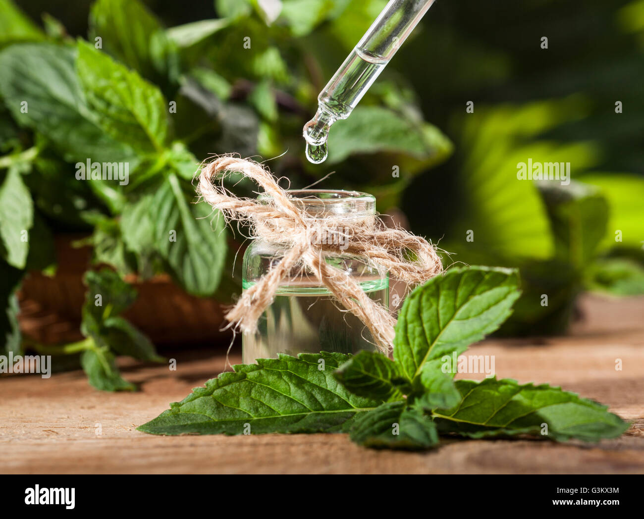 Aroma essenziale con olio di menta piperita su sfondo di legno. Messa a fuoco selettiva, orizzontale. Foto Stock