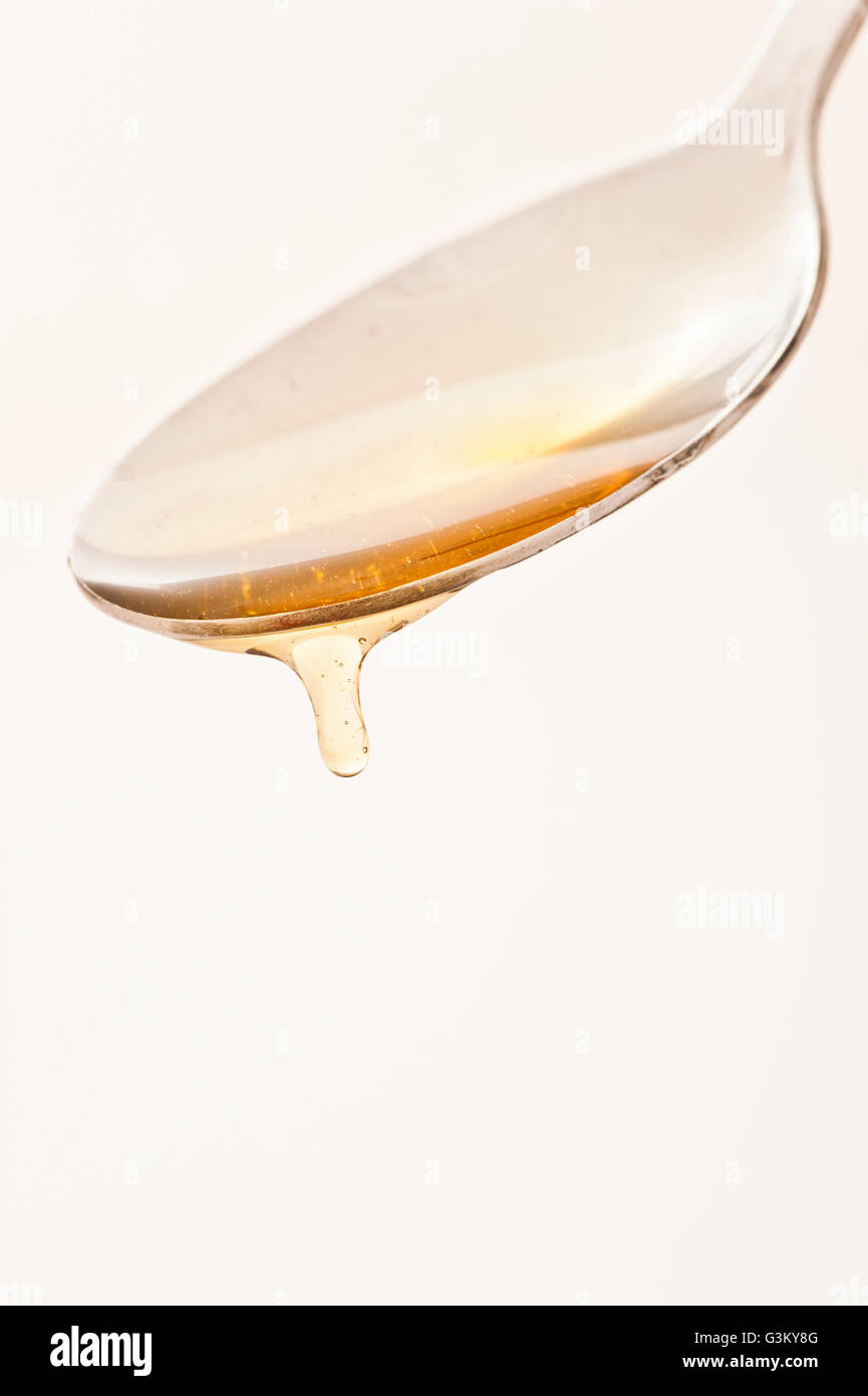 Cucchiaio con miele di gocciolamento Foto Stock
