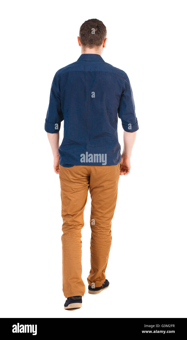 Vista posteriore di andare uomo bello in jeans e una maglietta. a piedi giovane ragazzo . Vista posteriore di raccolta persone. vista posteriore di persona. Isolato su sfondo bianco uomo in marrone pantaloni, shirt maniche rotolò in distanza. Foto Stock