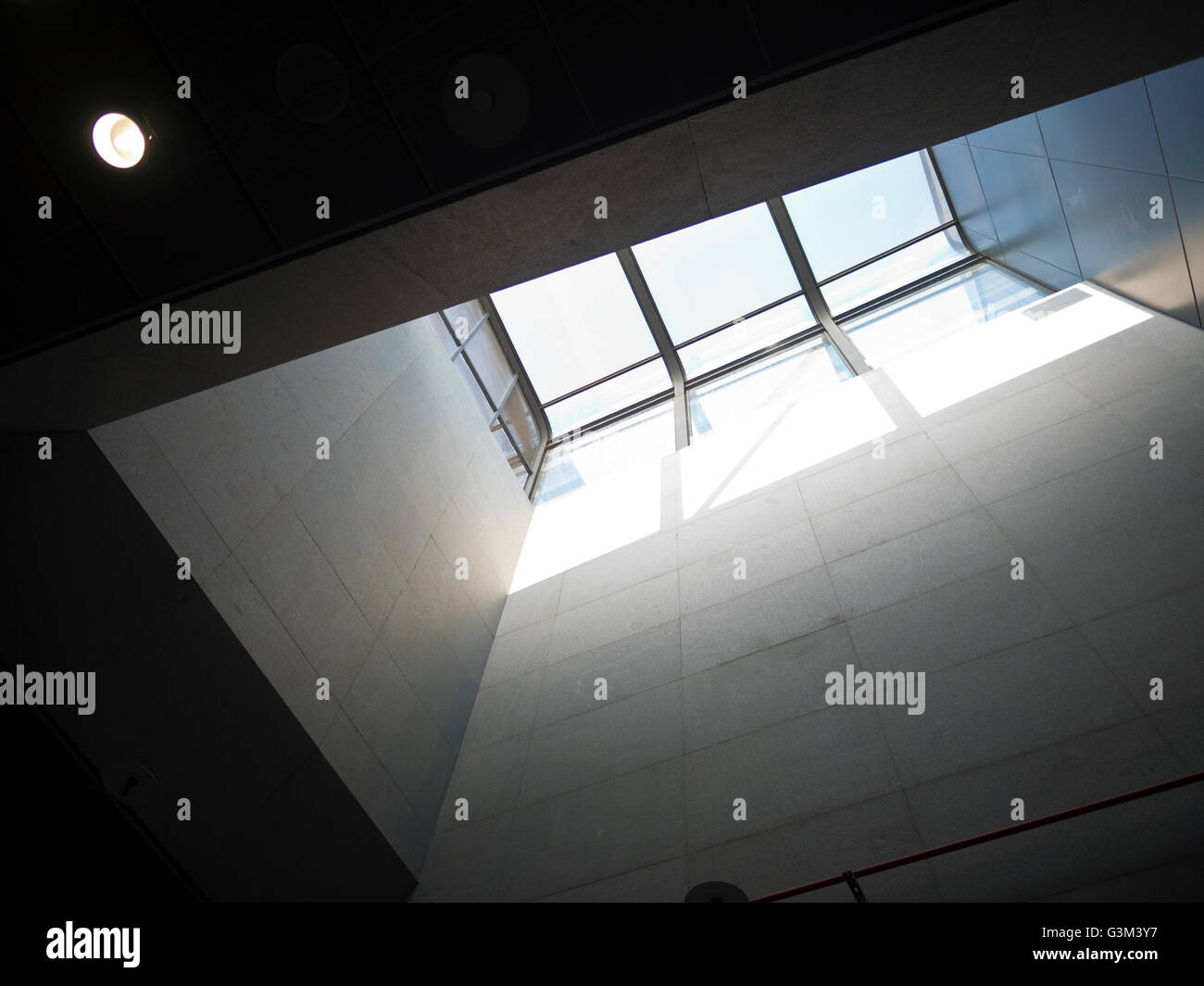 Cerca fino alla luce splendente cielo attraverso la moderna quardrilateral finestra sul soffitto Foto Stock