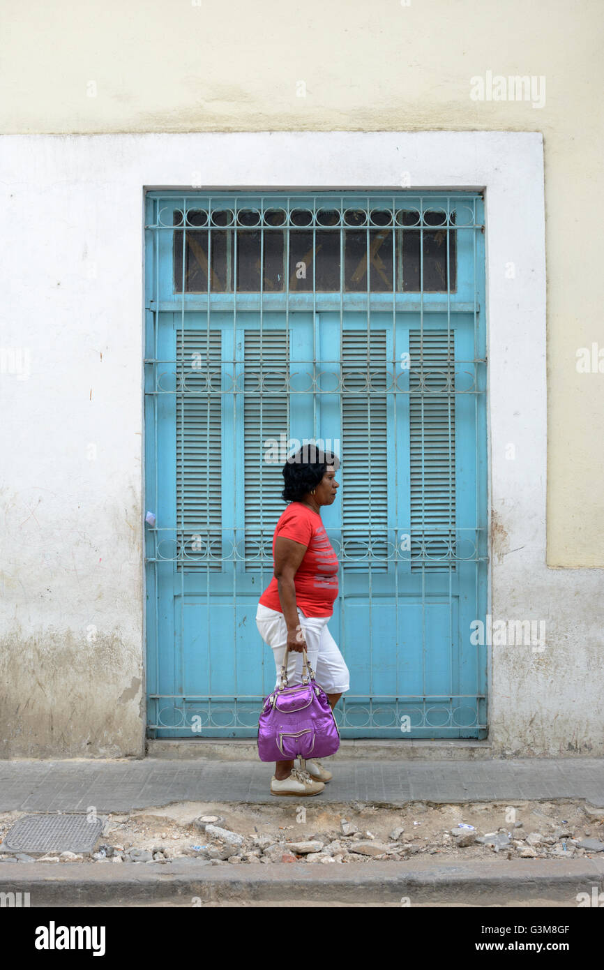 Una donna cammina davanti ad una tradizionale porta cubano nella Vecchia Havana, Cuba Foto Stock