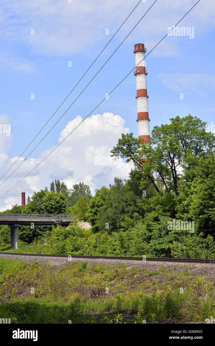 Caldaia industriale tubo su uno sfondo di verdi alberi Foto Stock
