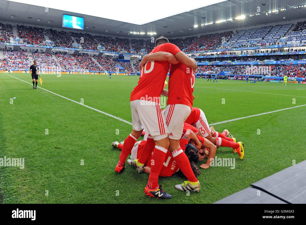 Hal Robson-Kanu del Galles (sotto i giocatori sul pavimento) viene assaliti dai suoi compagni di squadra dopo la sua fine seconda metà obiettivo che sigillò la vittoria per il Galles contro la Slovacchia nel loro Euro 2016 Gruppo B dispositivo di fissaggio con il Matmut Atlantique , Nouveau Stade de Bordeaux in Bordeaux, Francia Sabato 11 Giugno 2016. Foto Stock