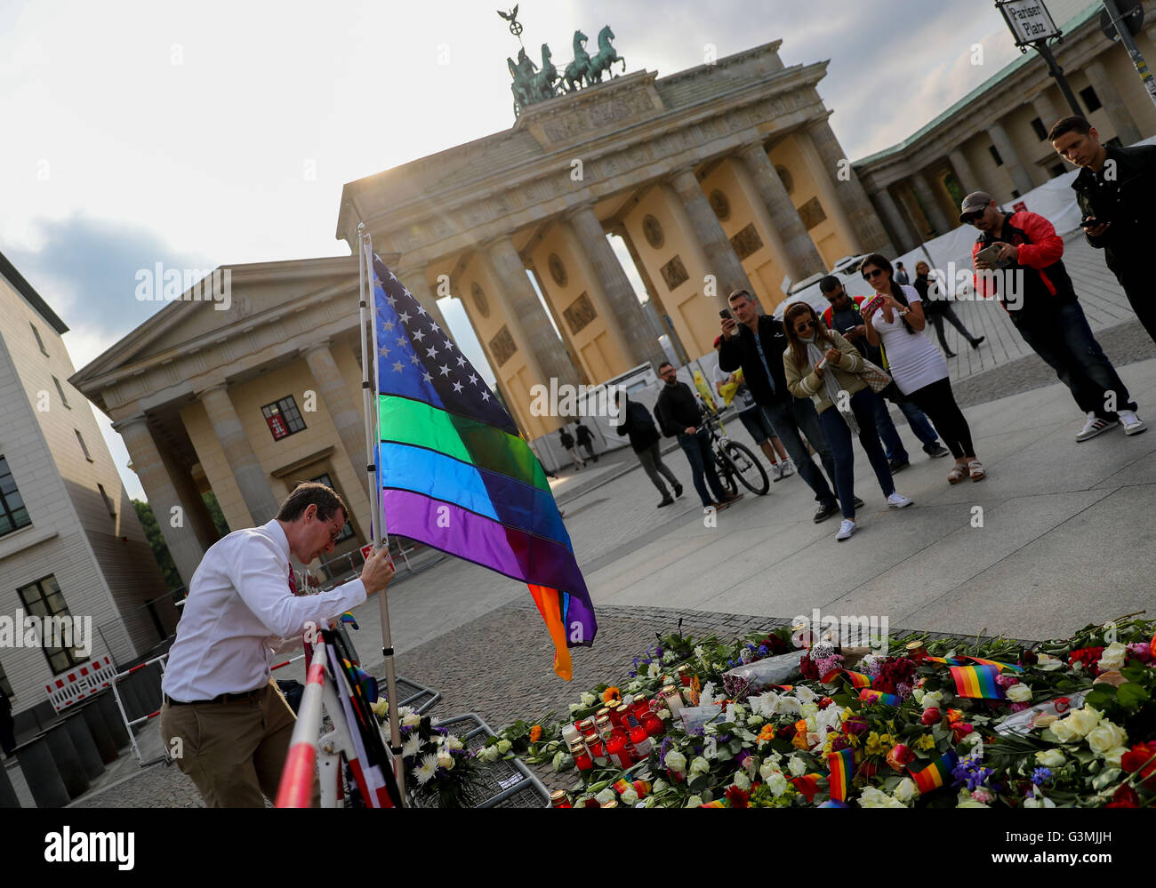 Berlino, Germania. Xiii Giugno, 2016. Un uomo imposta una bandiera arcobaleno di fronte all'ambasciata americana situata accanto alla Porta di Brandeburgo in memoria delle vittime dell'Orlando riprese di massa, a Berlino, Germania, 13 giugno 2016. Foto: KAY NIETFELD/dpa/Alamy Live News Foto Stock