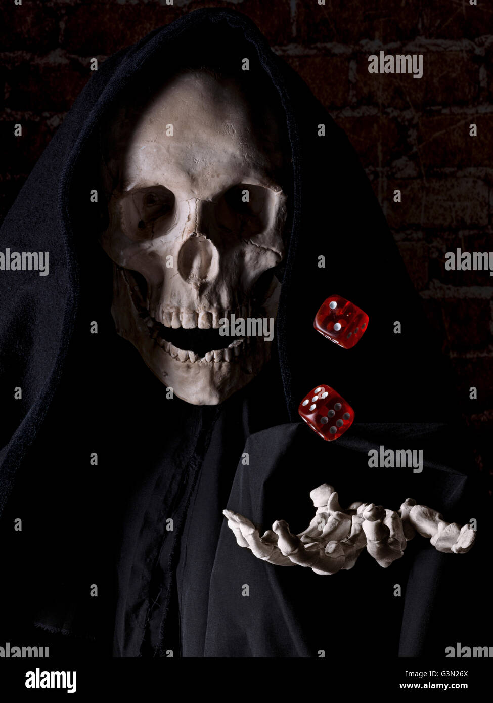 Cranio umano simulando la morte e una mano umana gettando le piastrine in aria Foto Stock