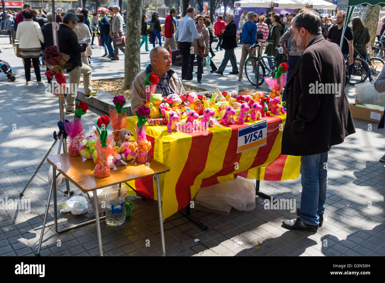 Lo stand di mercato con bandiere catalano di peluche vendita draghi su Diada de Sant Jordi (Saint George's Day), 23 aprile, Barcellona. Foto Stock
