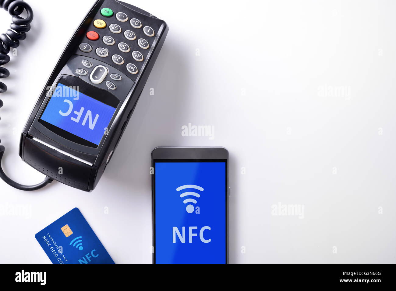 Telefono cellulare e pagamento con carta di credito in negozi con sistema NFC. Dettaglio della scheda POS e mobile su tavola bianco isolato. Vista superiore Foto Stock