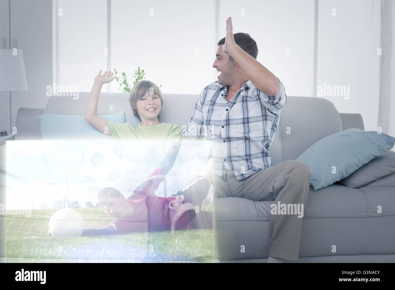 Immagine composita di padre e figlio dando ad alta cinque nella parte anteriore della partita di calcio in televisione Foto Stock