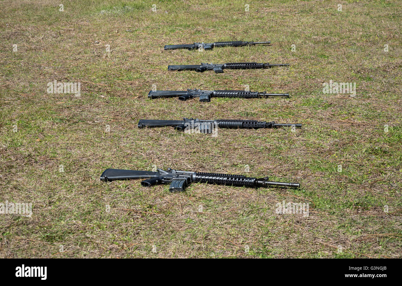 Armi automatiche giacente in erba durante la cerimonia. Foto Stock