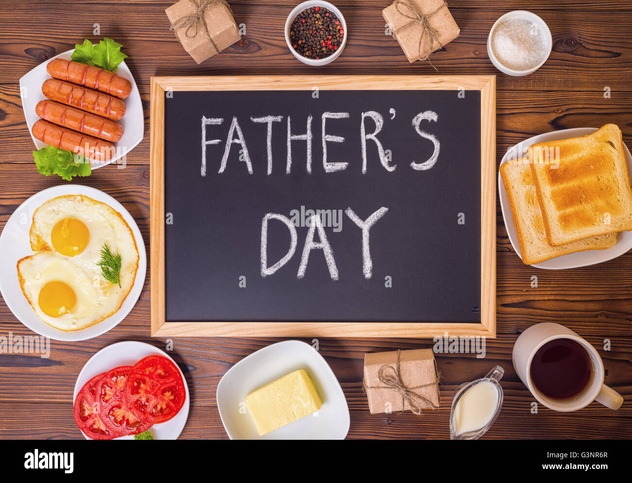 Vista superiore del concetto del papà con il testo scritto a mano sulla lavagna con impostazione colazione e confezione regalo su sfondo di legno Foto Stock