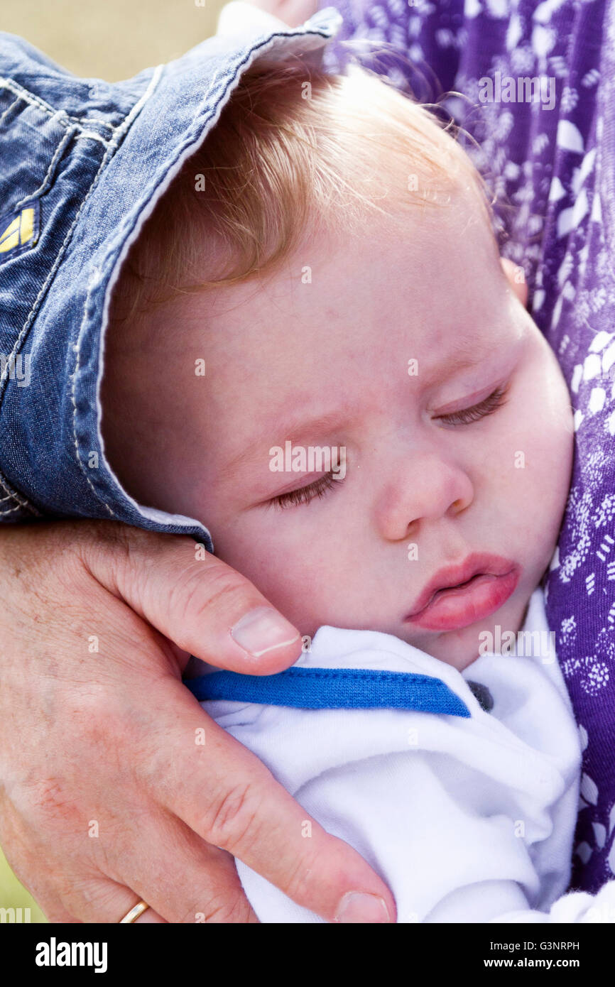 Bambino addormentato nella sua nonne bracci Foto Stock