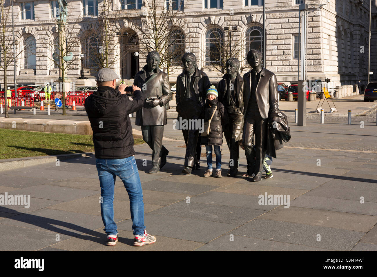 Merseyside, Liverpool, Pier Head Andrew Edwards del Beatles statua fuori Liver Building, i visitatori di prendere foto ricordo Foto Stock