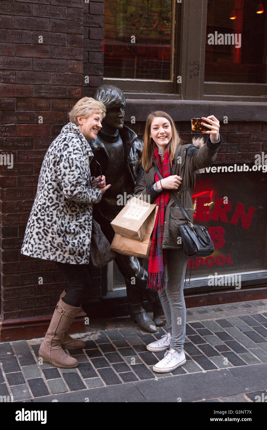Merseyside, Liverpool, Mathew Street, turisti tenendo selfie con John Lennon statua da Arthur Dooley Foto Stock