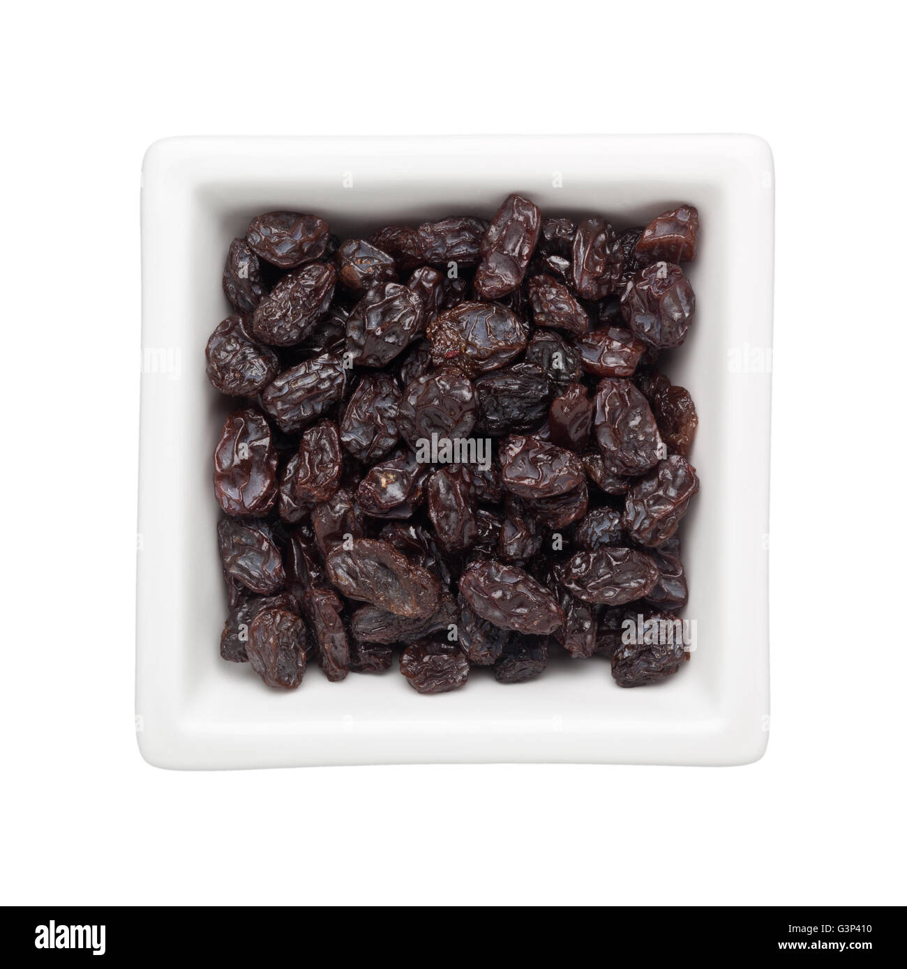 L'uvetta in un recipiente quadrato isolato su sfondo bianco Foto Stock