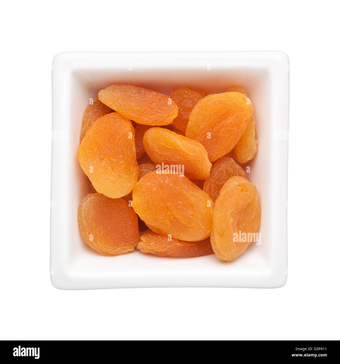 Albicocche secche in un recipiente quadrato isolato su sfondo bianco Foto Stock