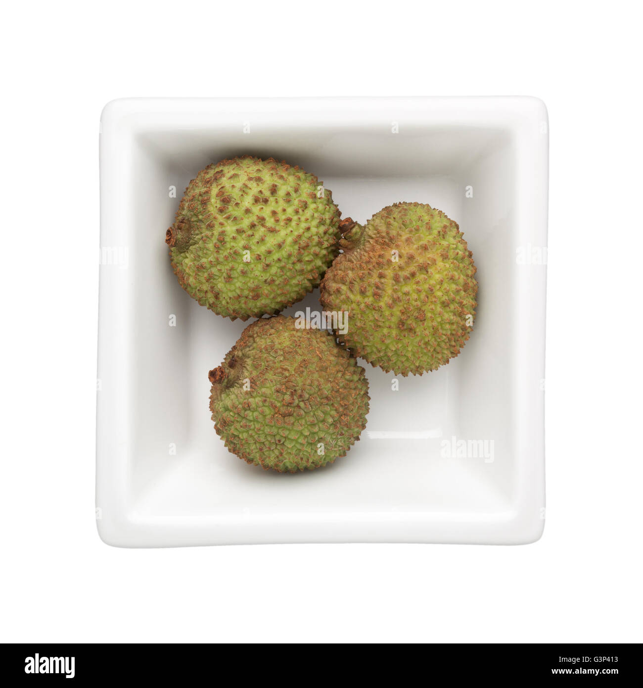 Litchi verde in un recipiente quadrato isolato su sfondo bianco Foto Stock