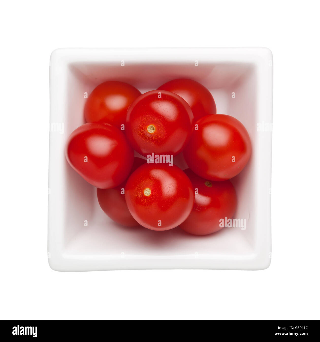 Pomodori ciliegia in un recipiente quadrato isolato su sfondo bianco Foto Stock