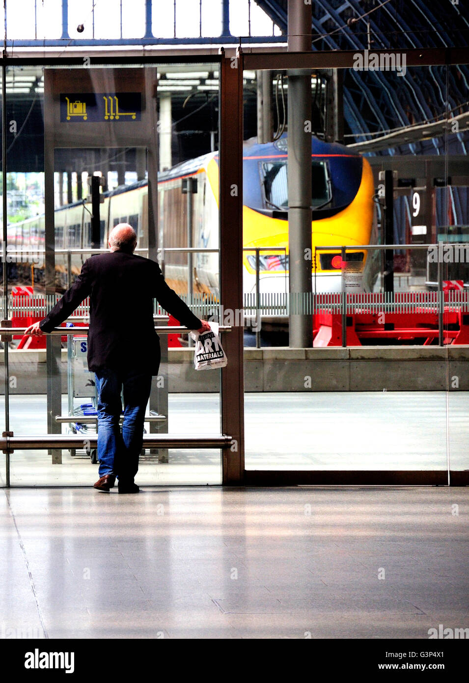 Londra, Inghilterra, Regno Unito. Dalla stazione ferroviaria internazionale di St Pancras. Uomo in attesa dal terminal Eurostar Foto Stock