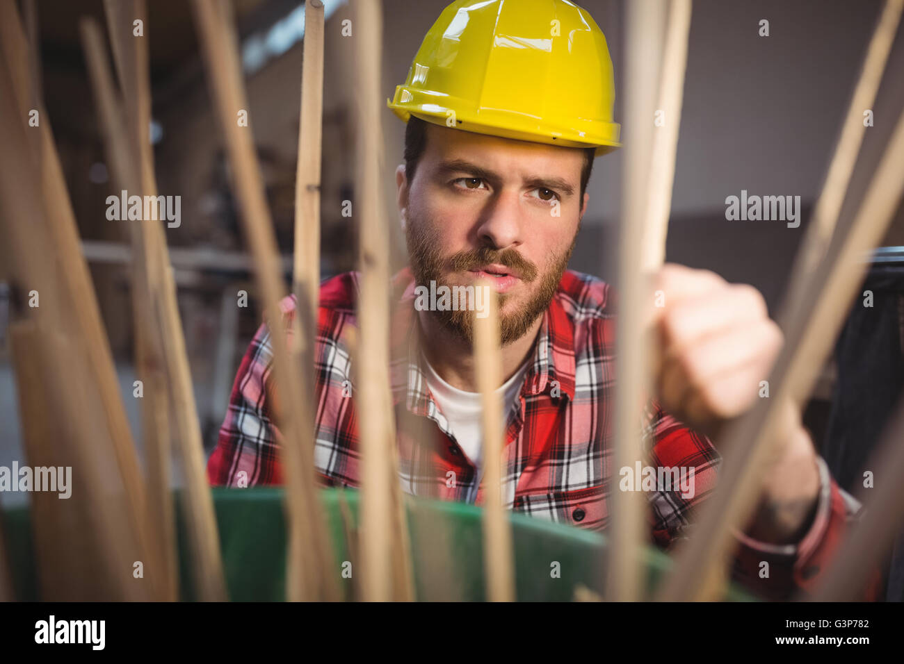 Carpenter guardando il bastone di legno Foto Stock
