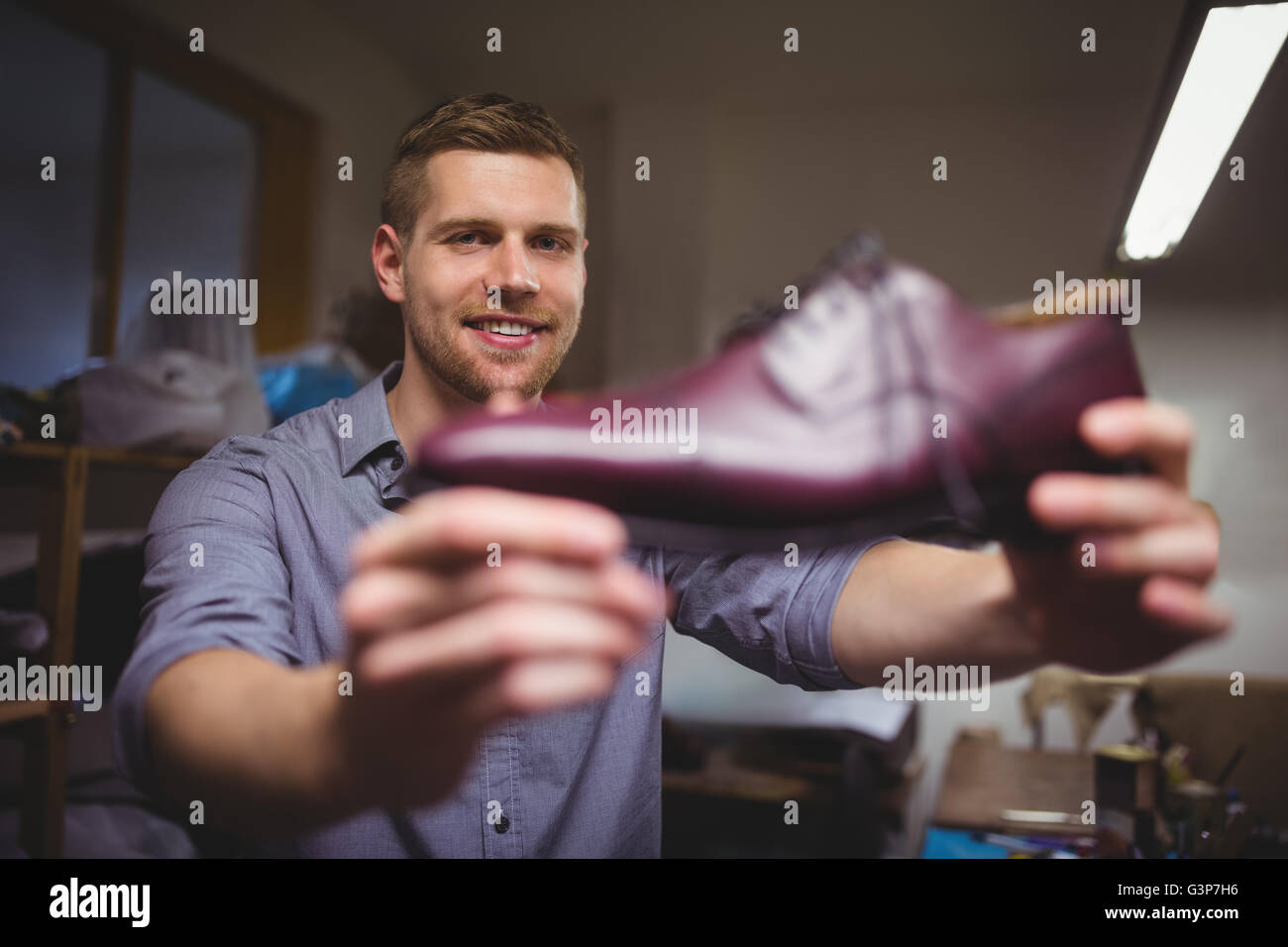 Il comando cobbler tenendo una scarpa Foto Stock