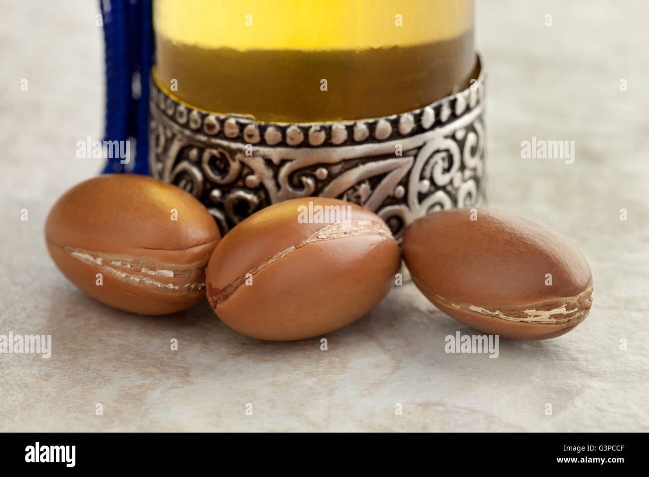 Bottiglia con marocchino olio di argan e i dadi da vicino Foto Stock