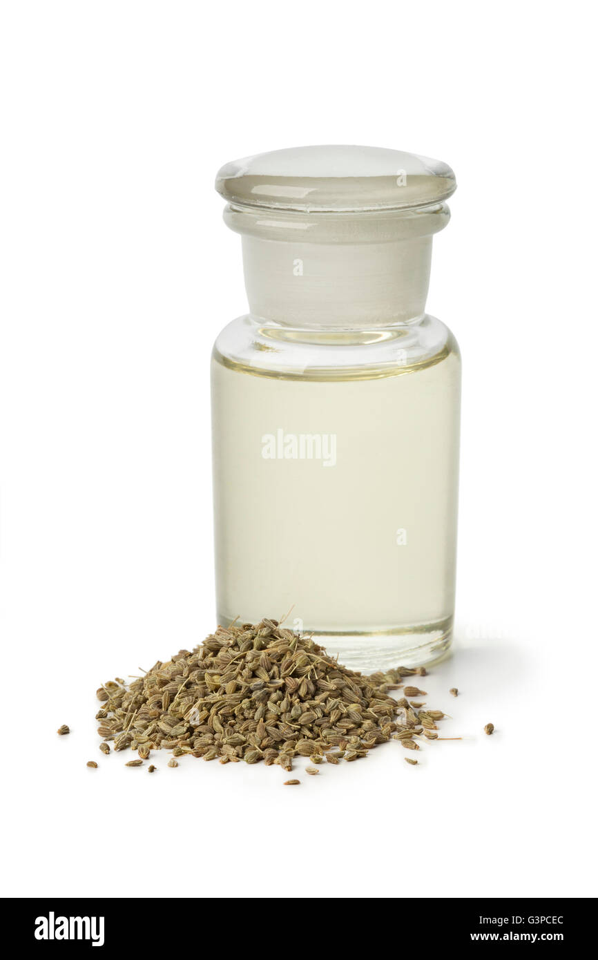 Bottiglia con olio di anice e semi su sfondo bianco Foto Stock