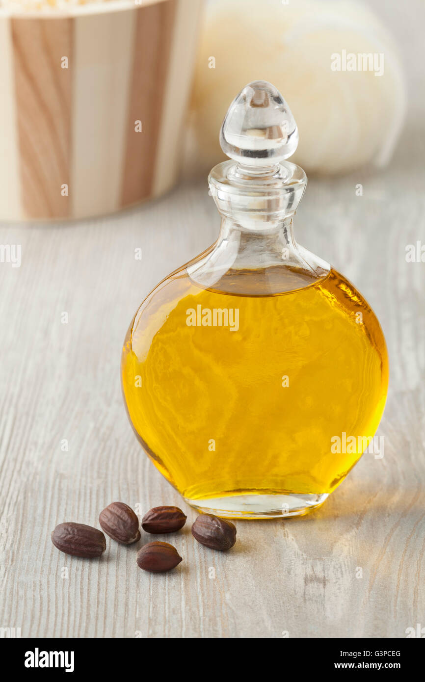 Bottiglia di cosmetici di olio di jojoba e semi Foto Stock