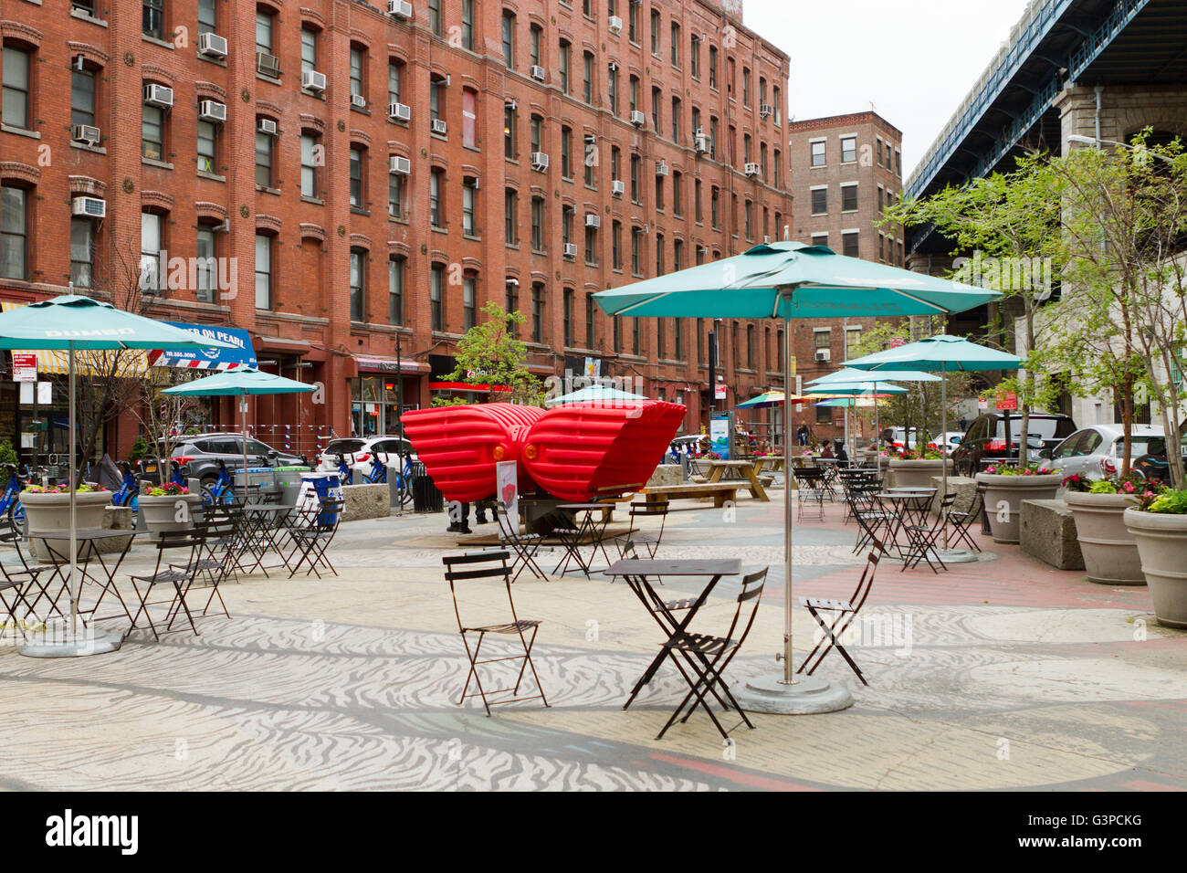 Piazza urbana a Brooklyn sotto il ponte di Manhattan e un terrazzo con sedie e arte di installazione chiamato cuore sede Foto Stock