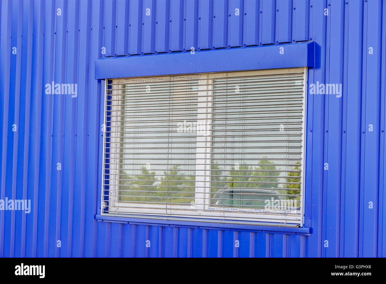 Primo piano blu forato a parete in alluminio e vetro Foto Stock