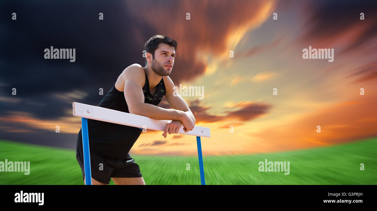 Immagine composita di atletica uomo pressato su un ostacolo in posa Foto Stock