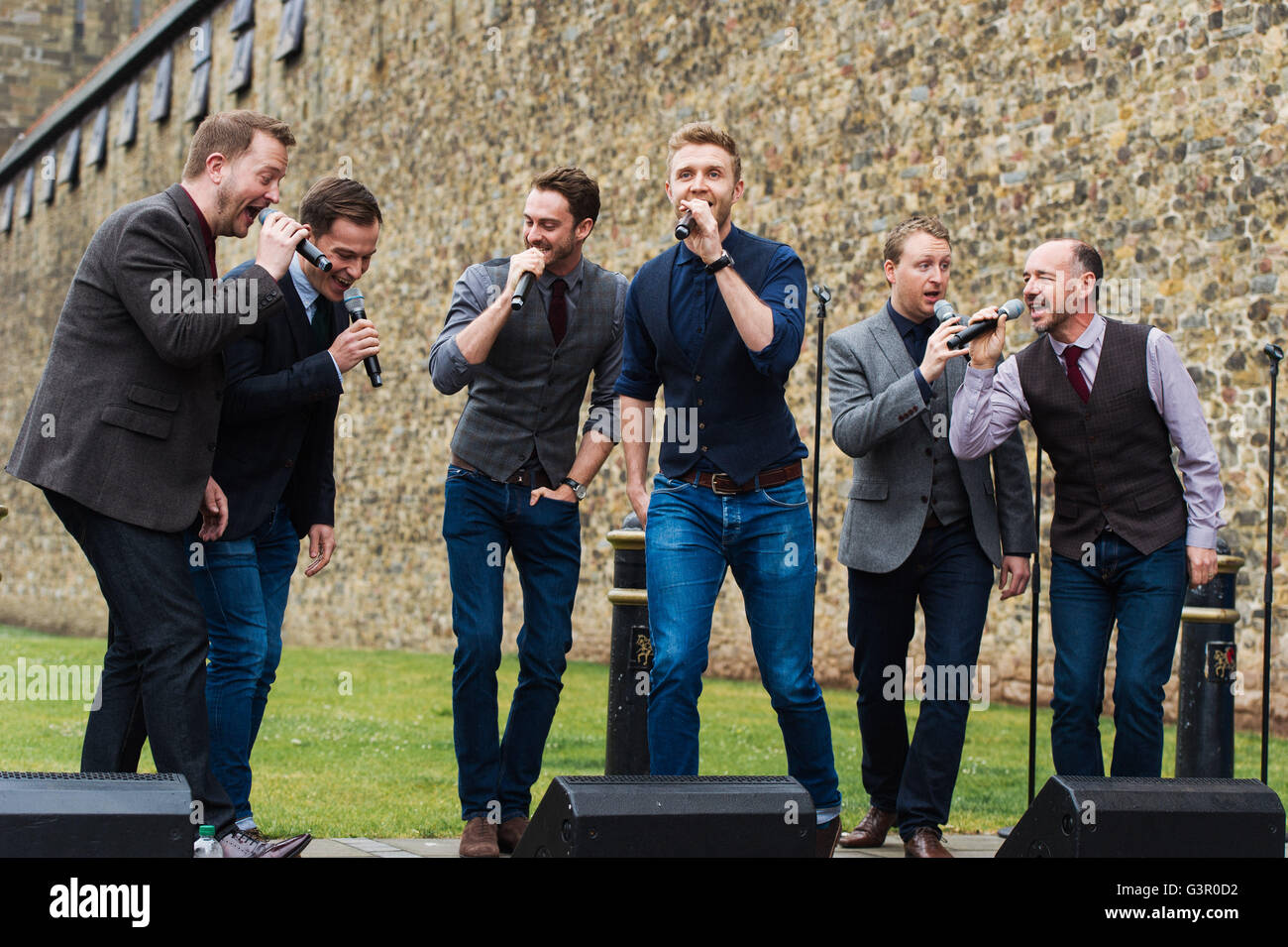 Solo gli uomini ad alta voce eseguire al di fuori del Castello di Cardiff come parte del coro orologio durante Wales Millennium Centre inaugurale del Festival della voce. Foto Stock