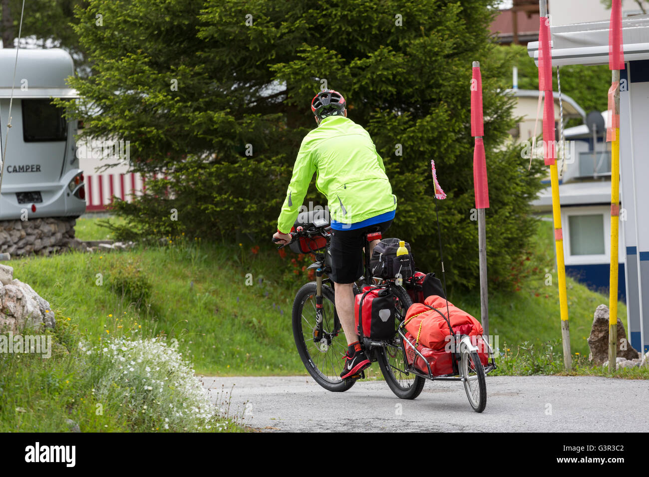 Un maschio senior ciclista sulla bici con rimorchio Foto Stock