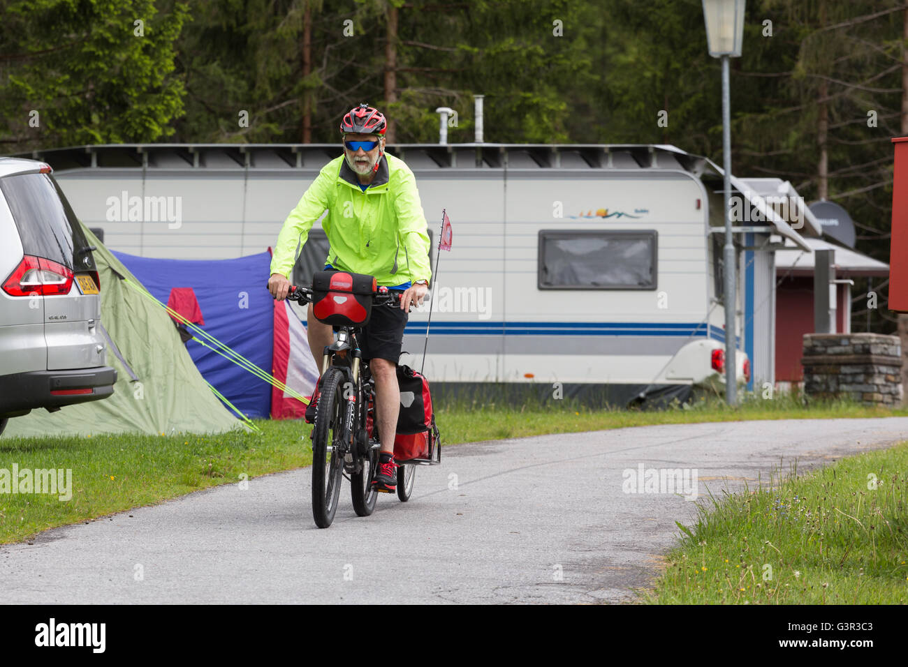 Un maschio senior ciclista sulla bici con rimorchio Foto Stock