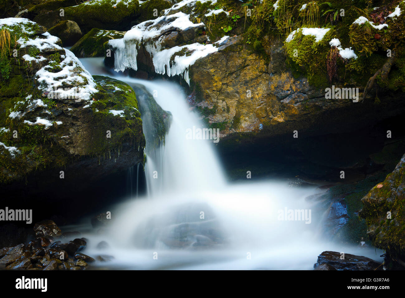 Una piccola cascata durante il periodo invernale con motion blur, Haute Savoie, Francia. Foto Stock