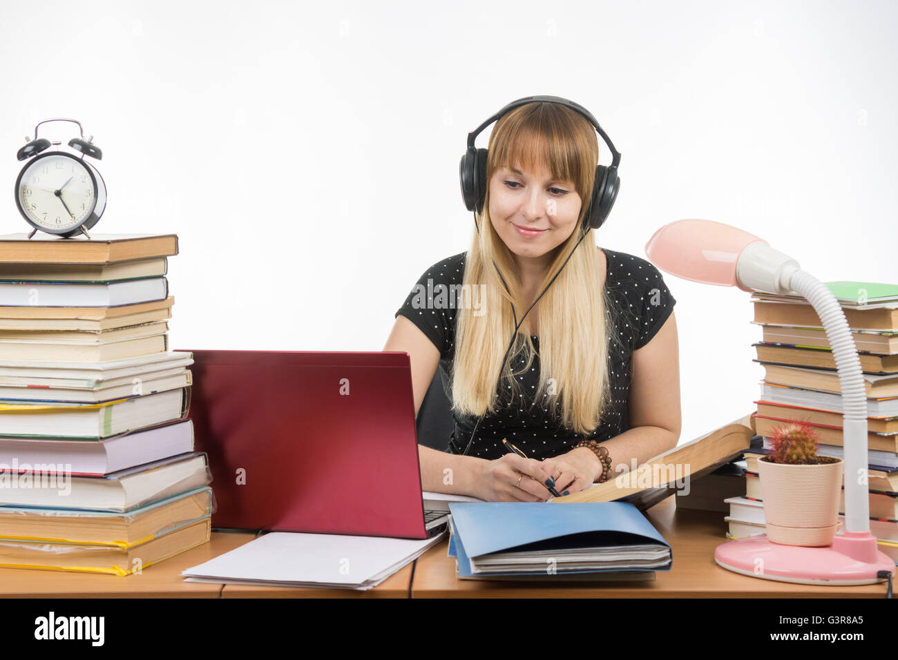 Studente con le cuffie pronto a passare il progetto di diploma è alla ricerca di informazioni su Internet Foto Stock