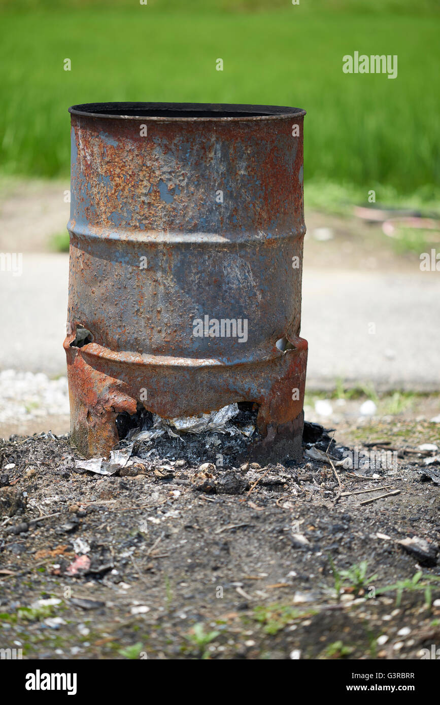 Un molto vecchio arrugginito cilindretto metallico con un foro sul fondo e cestino uscente, girato con una profondità di campo per una bella Foto Stock