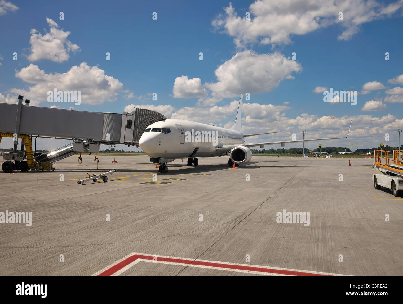 Bianco piano passeggero parcheggiato sul piazzale dell'aeroporto al cancello Foto Stock