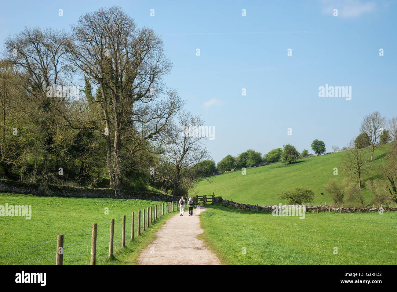 Coppia di anziani godendo di una passeggiata in Bradford dale vicino Youlgreave nel Peak District. Una soleggiata mattina d'estate. Foto Stock
