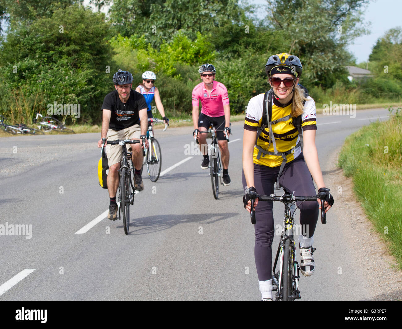 Due coppie in bicicletta sulla strada di un paese Foto Stock